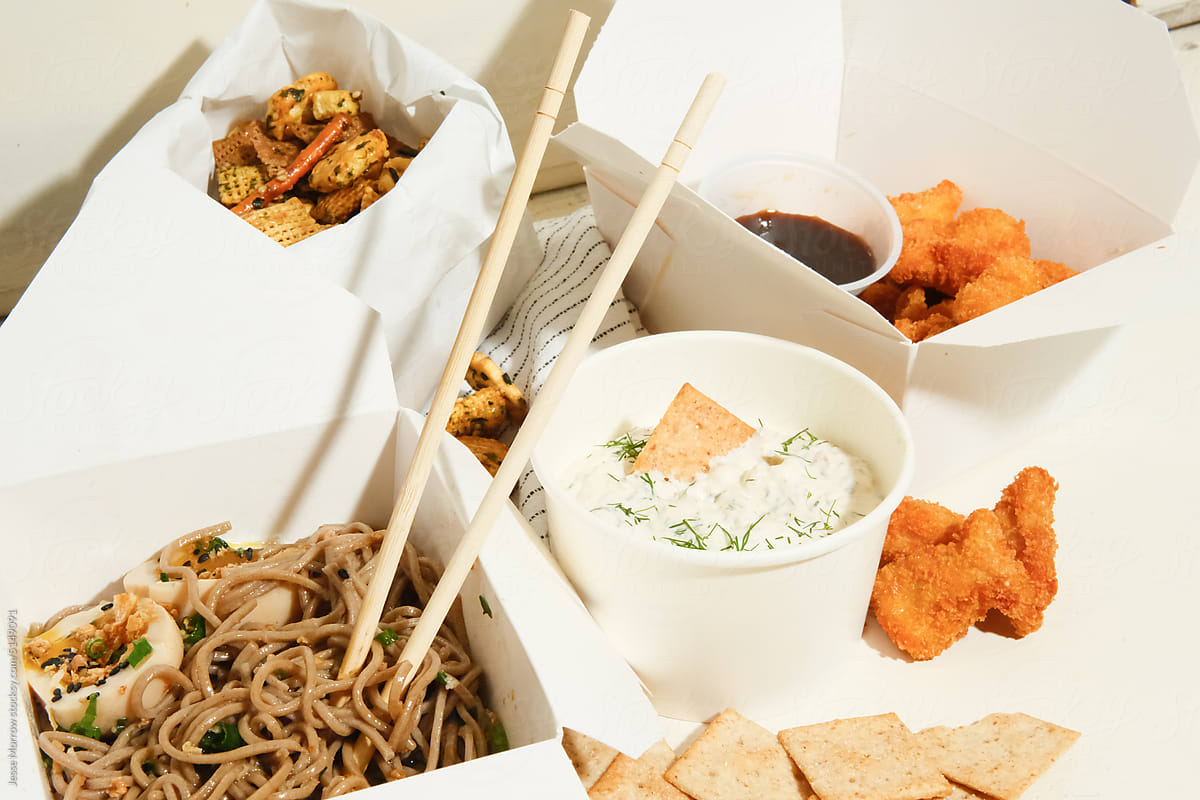 variety of food truck dishes in to-go containers on table