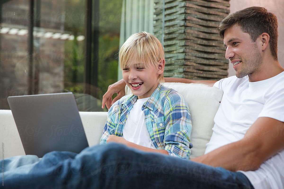 Father and son watching movie on a laptop
