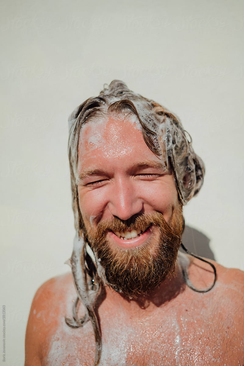 A Portarit Of A Man Smiling Covered In A Shampoo With His Eyes Closed