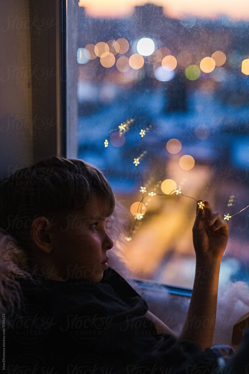 Boy on the window holding a star