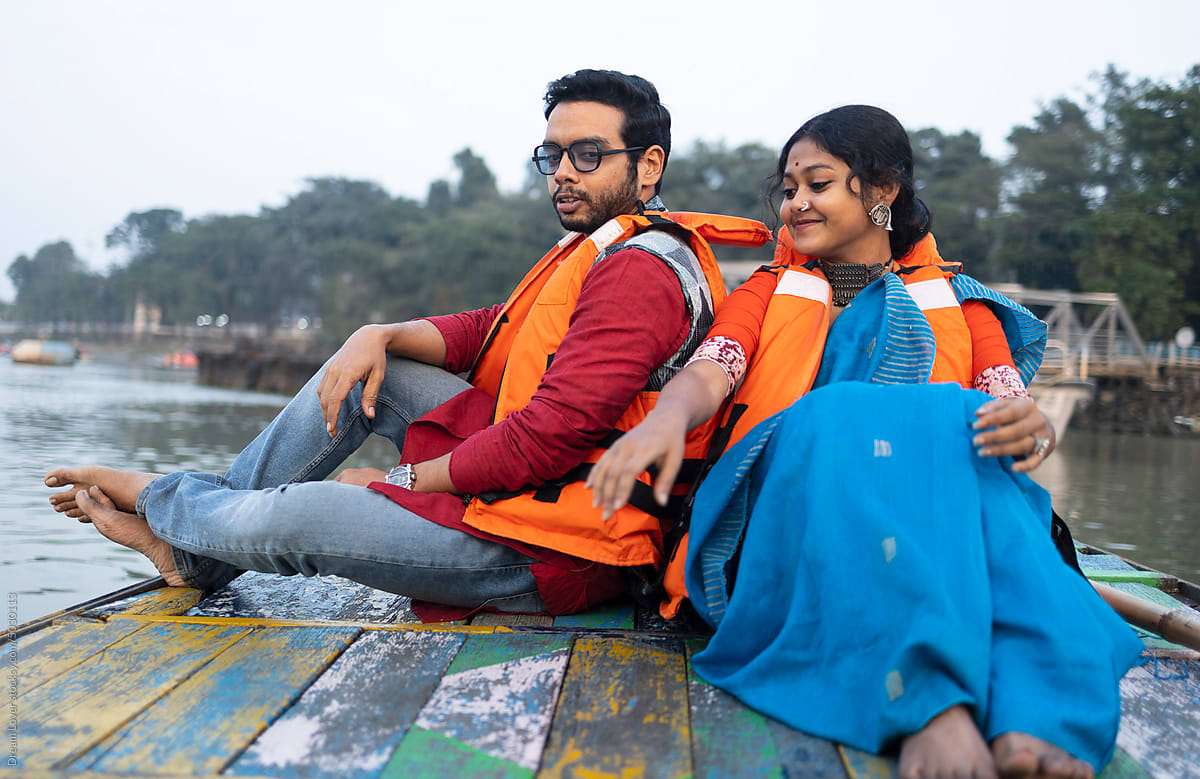 Young Couple Enjoying Travel Sitting On A Boat Over River Ganga,India