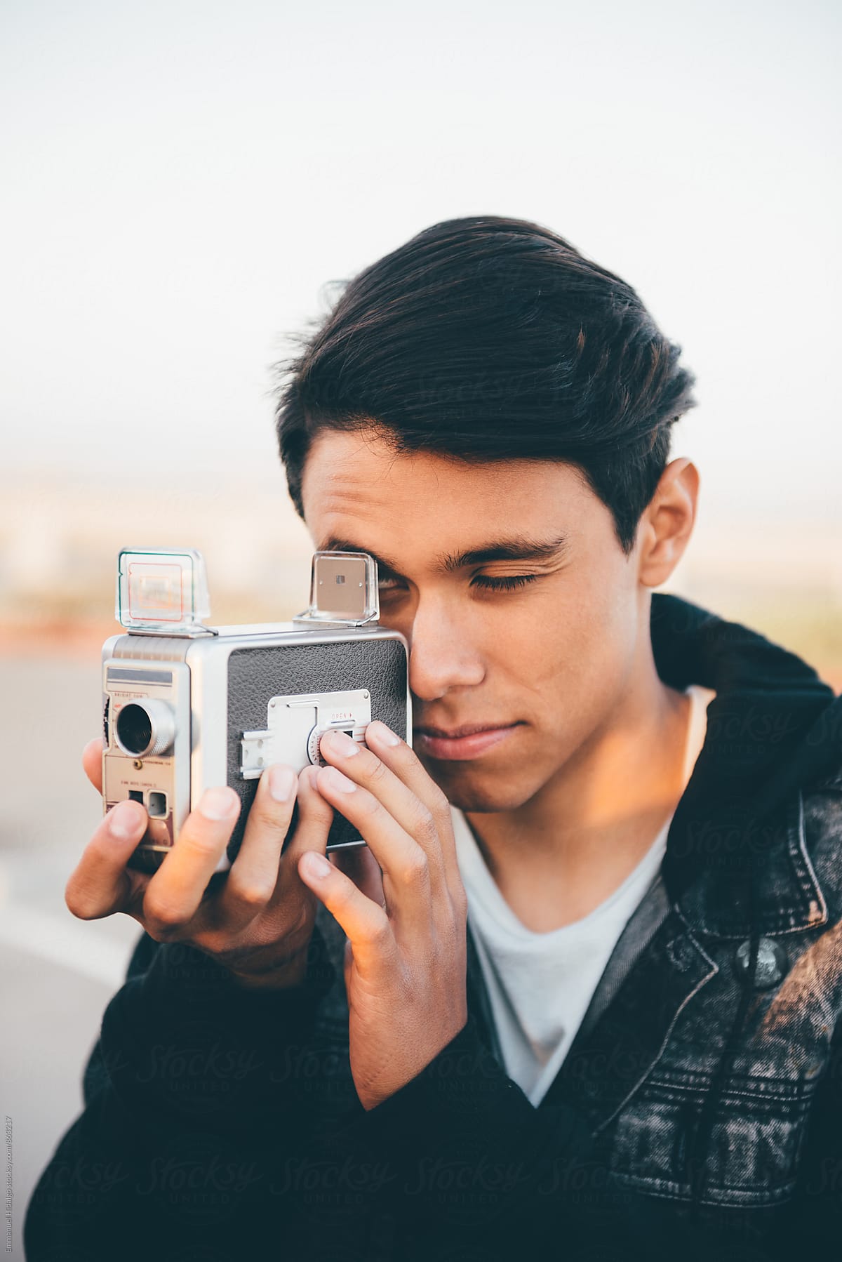 Young male going analog with vintage movie camera