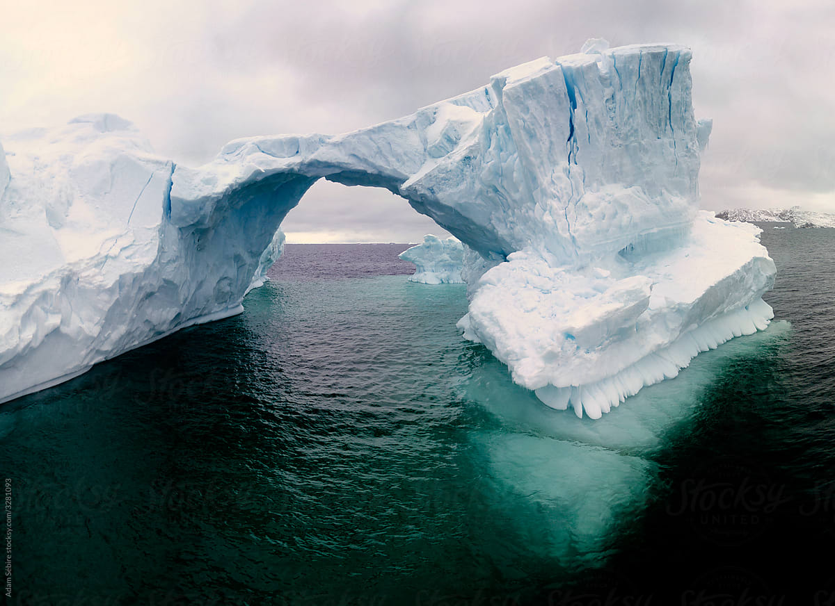 Beautiful Greenland iceberg arch melting, fractured, cracking