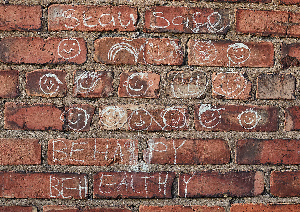 A childs drawing with chalk on a brick wall