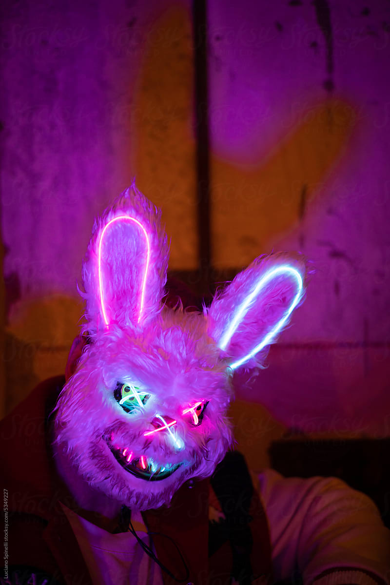 Man wearing creepy rabbit mask sitting on couch at freaky disco party