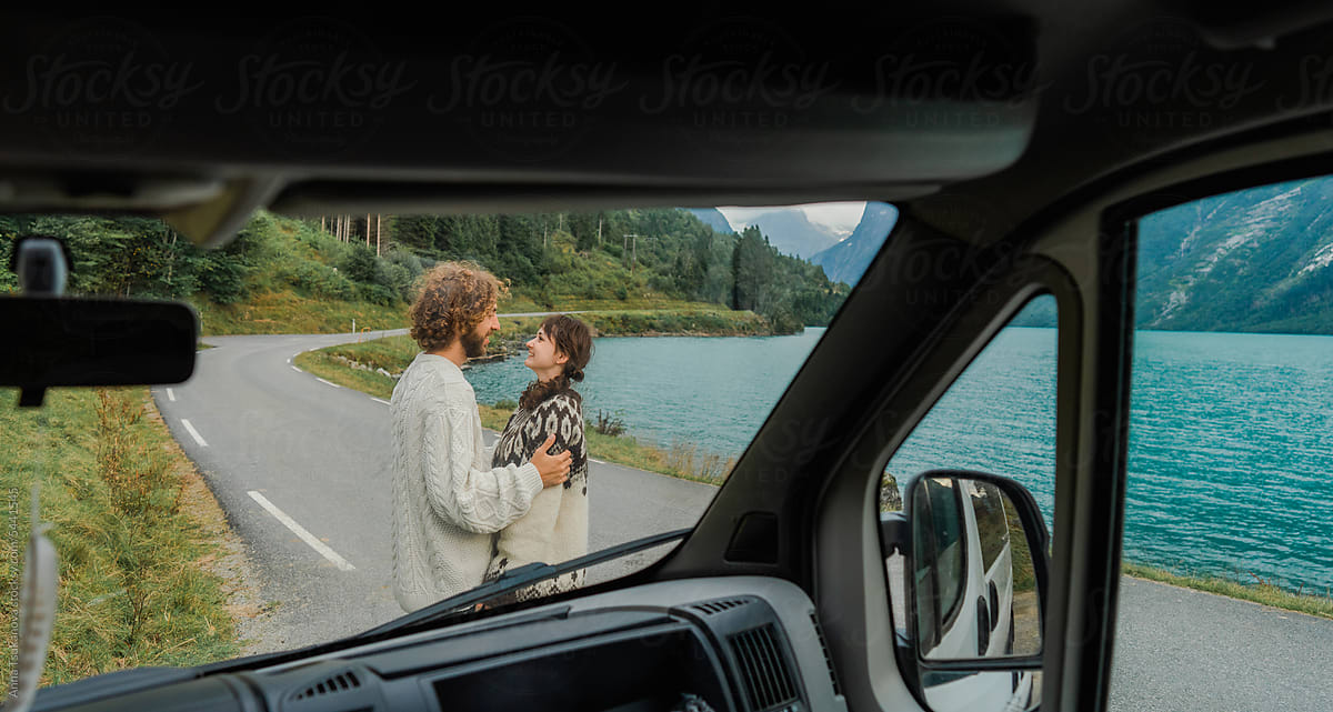 Couple on the road near the lake, view from camper van