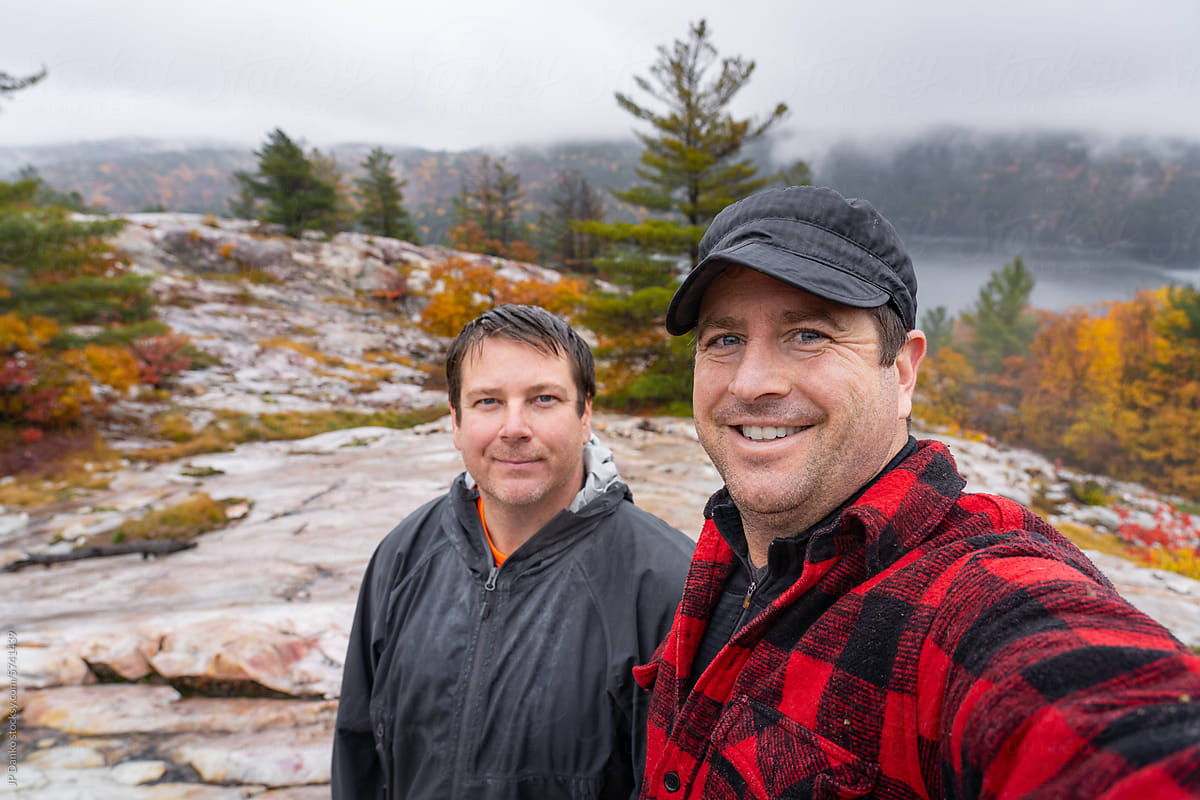 Friends Selfie at Outlook over Autumn Forest and Lake in Rain