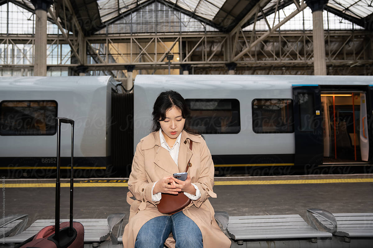 Woman Using Phone At Train Station