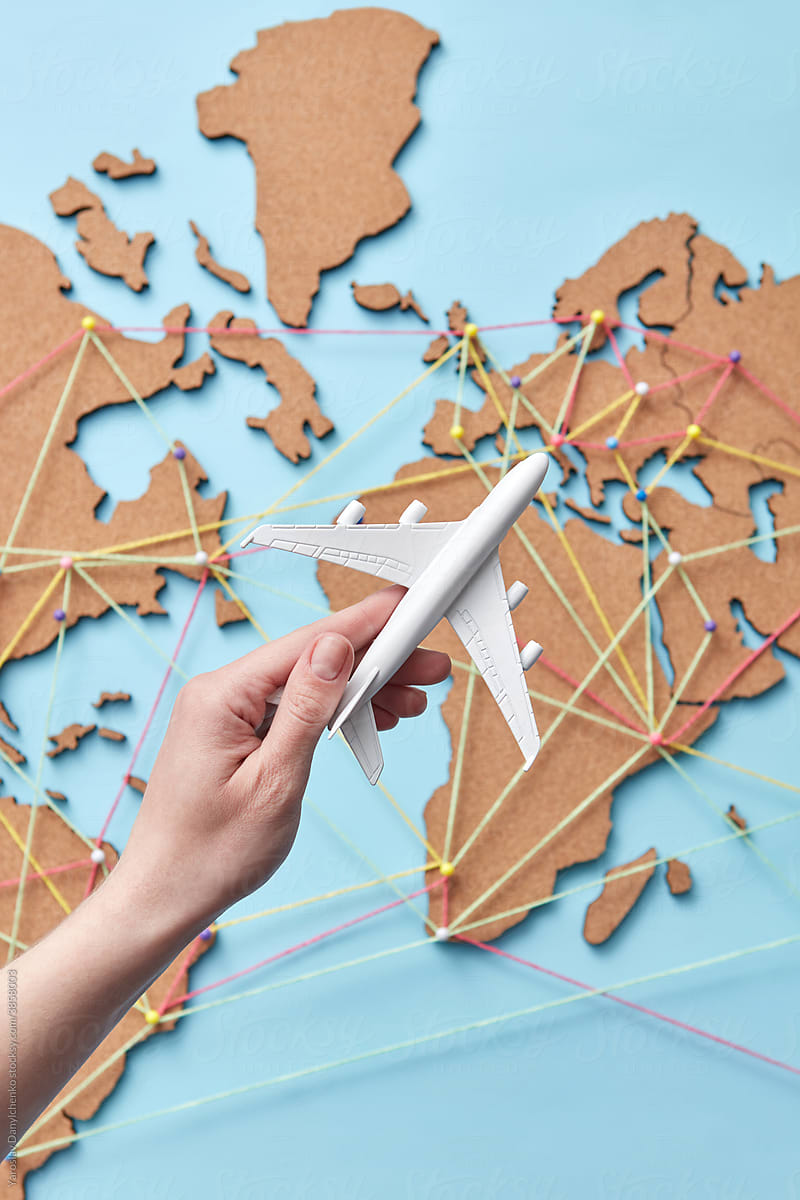 Woman holding plane model above map with connections