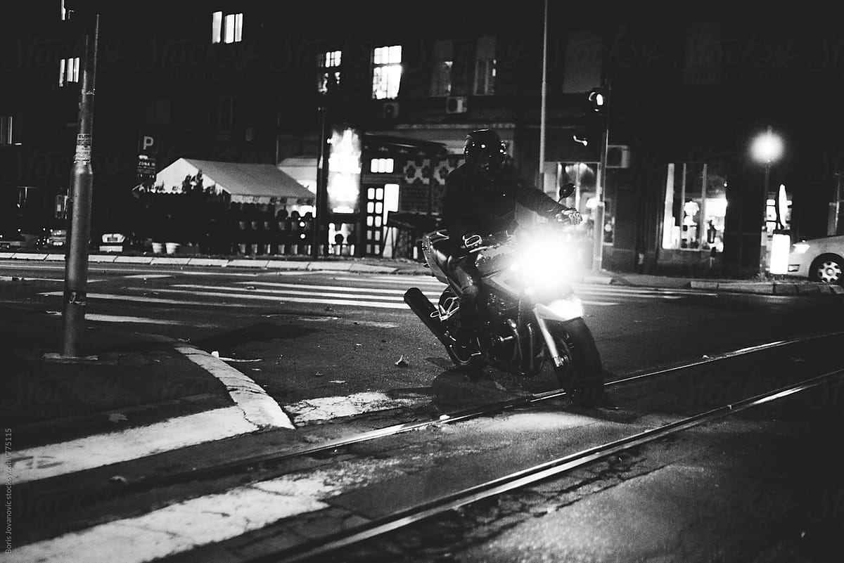 Biker riding a motorcycle on the street at night
