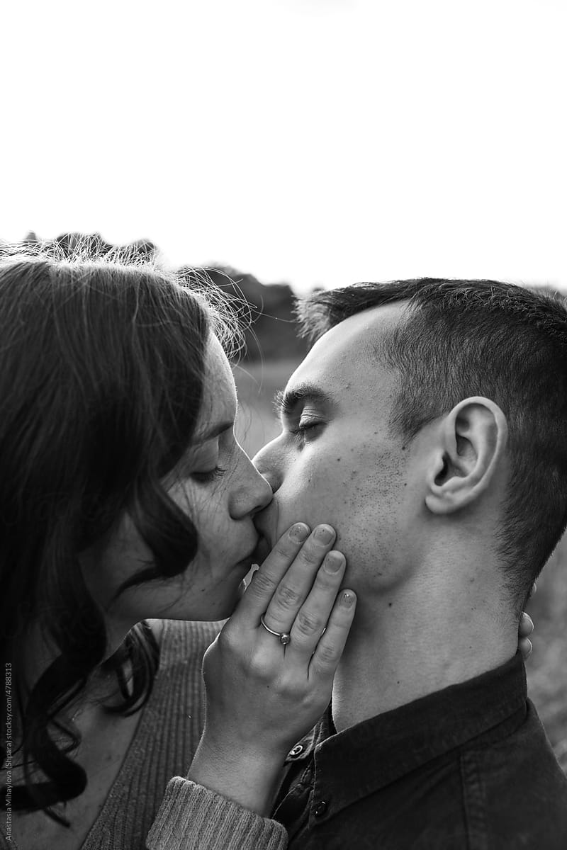 Black and white photo portrait of a loving kissing couple