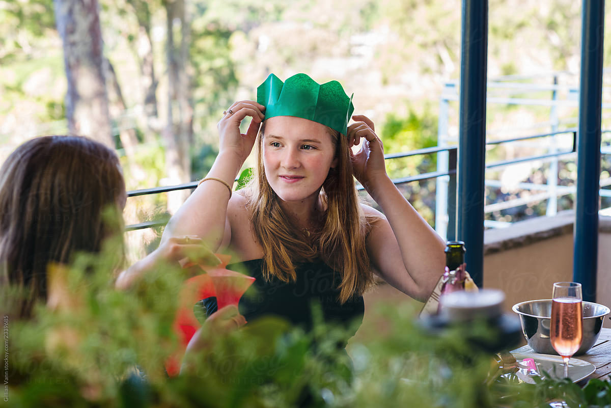 teen wearing a christmas  paper hat