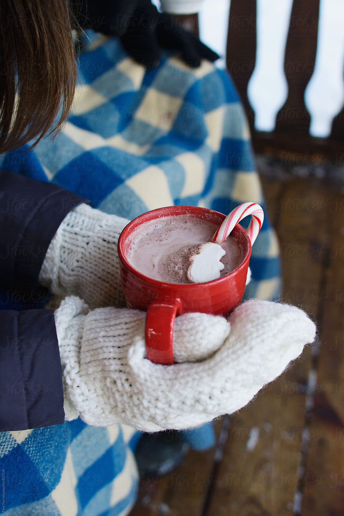person holding cup of cocoa outside on porch