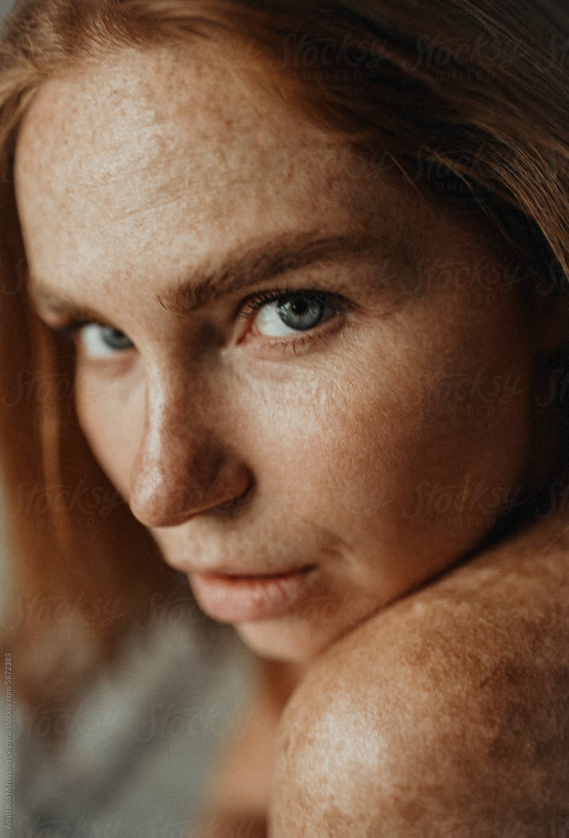 Close Up woman's portrait of Ginger female with many freckles on face