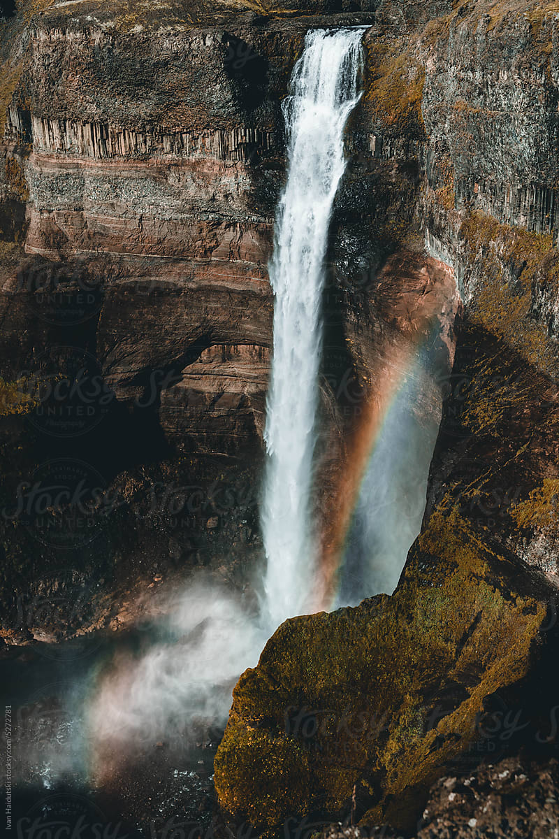 waterfall on cliff and rainbow