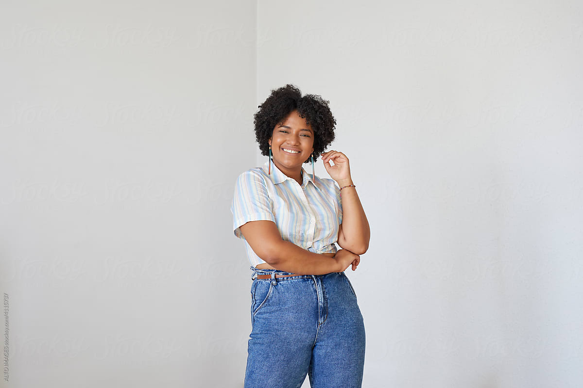 Positive black woman in shirt and jeans