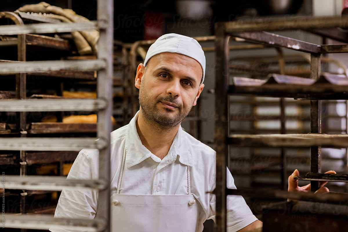 Portrait of a pastry chef in white uniform resting in the pastry shop