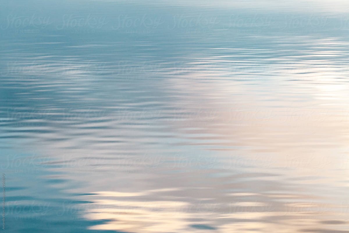 Sunrise reflected against the surface of a calm lake