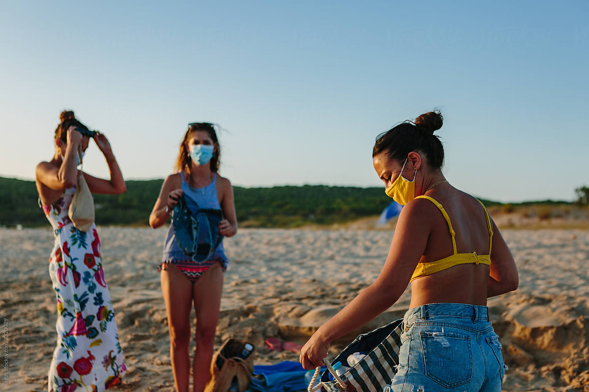 Facemask wearing friends packing to leave