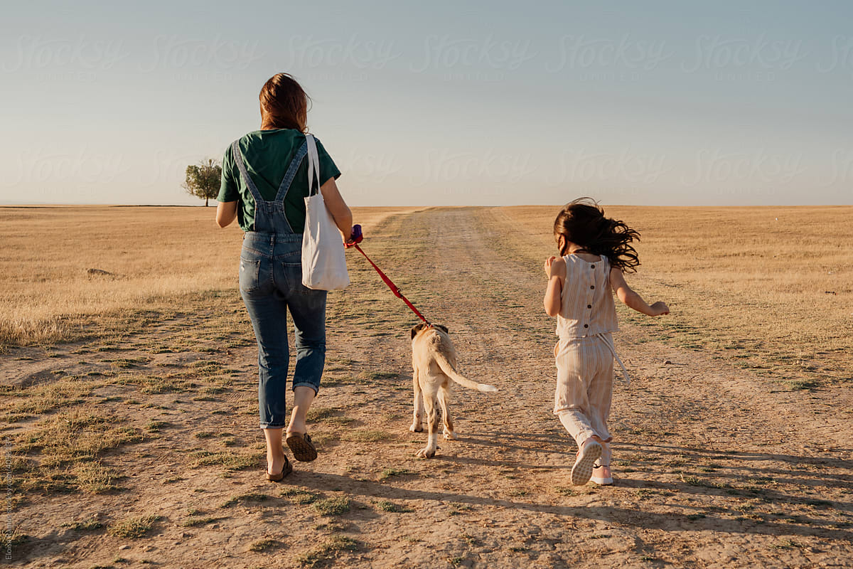 Family walking the dog at field