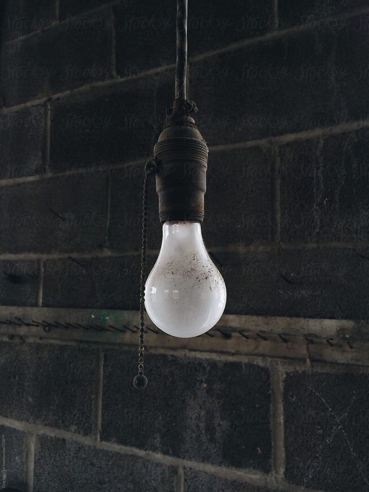 Sincle light bulb hanging from a ceiling in an abandoned garage