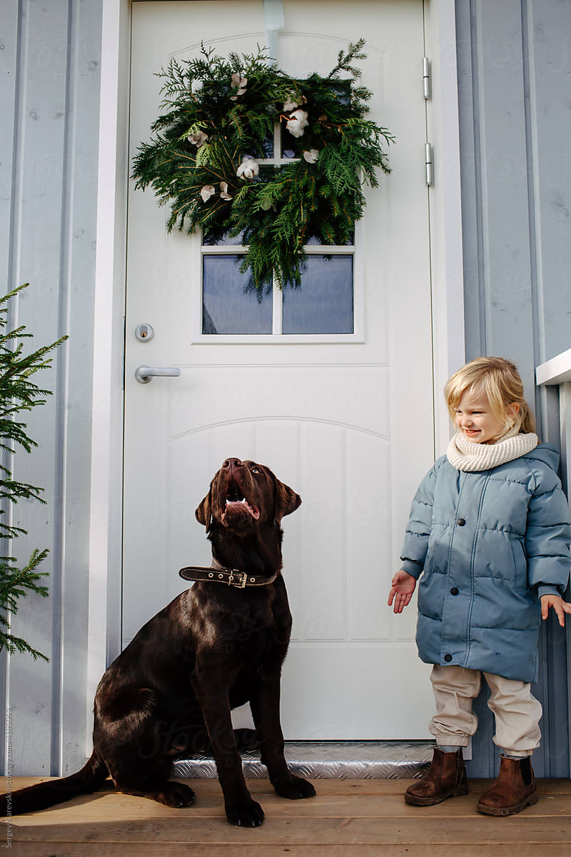Labrador and child near house entrance