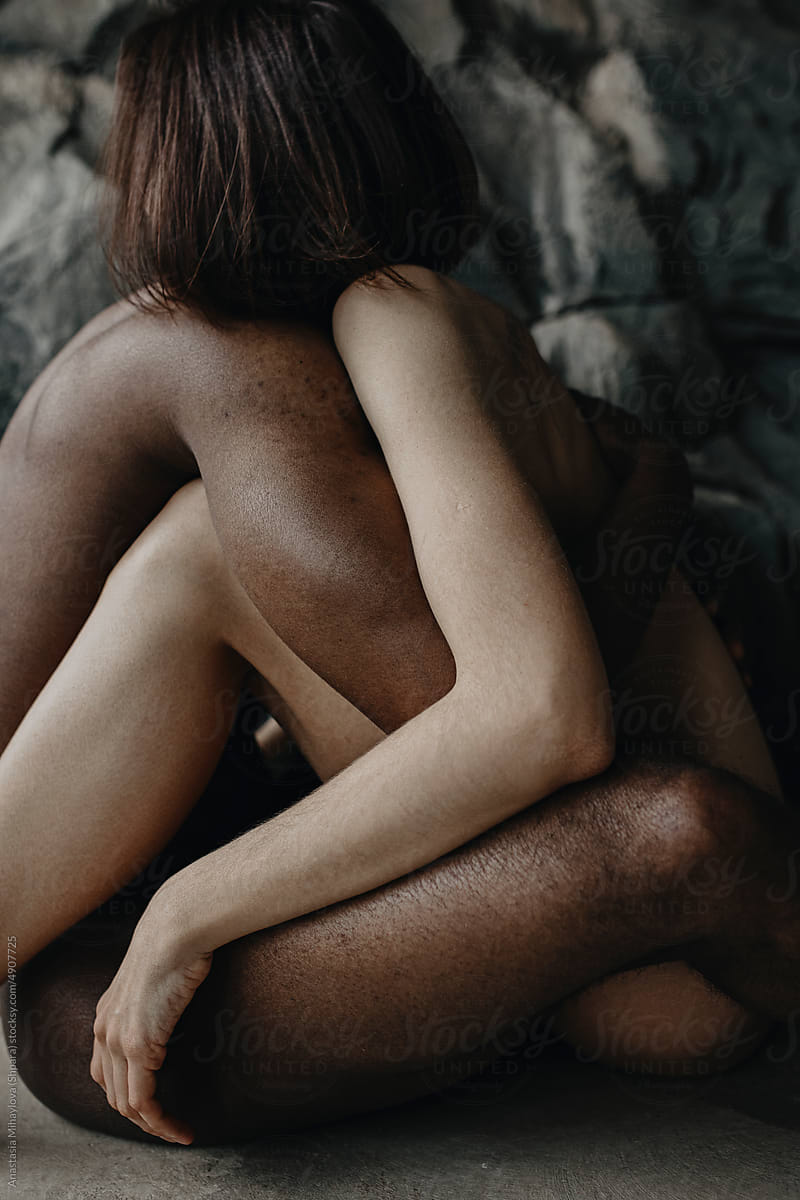 Multiracial couple hugging while sitting, Multiethnic Love Couple