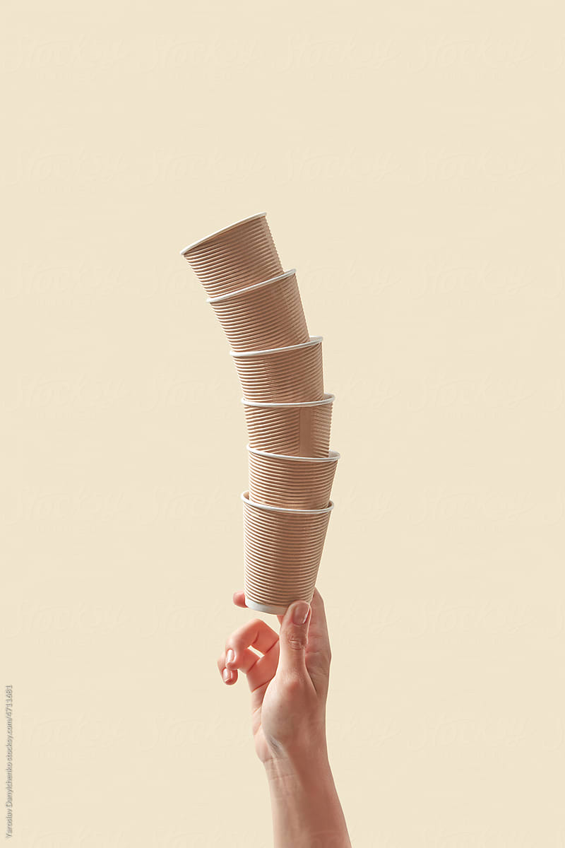 Brown-colored paper cups tower in female hand.