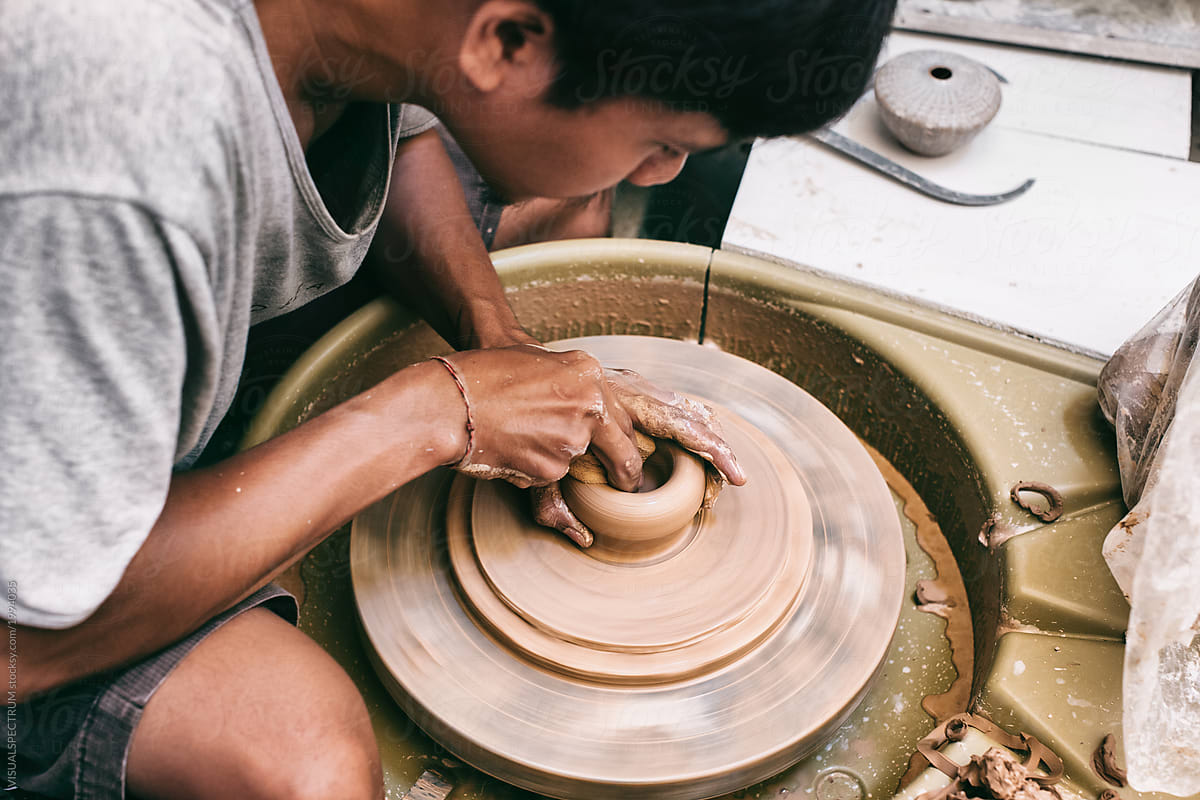 Male Artisan Potter Working on Vase on Spinning Flywheel