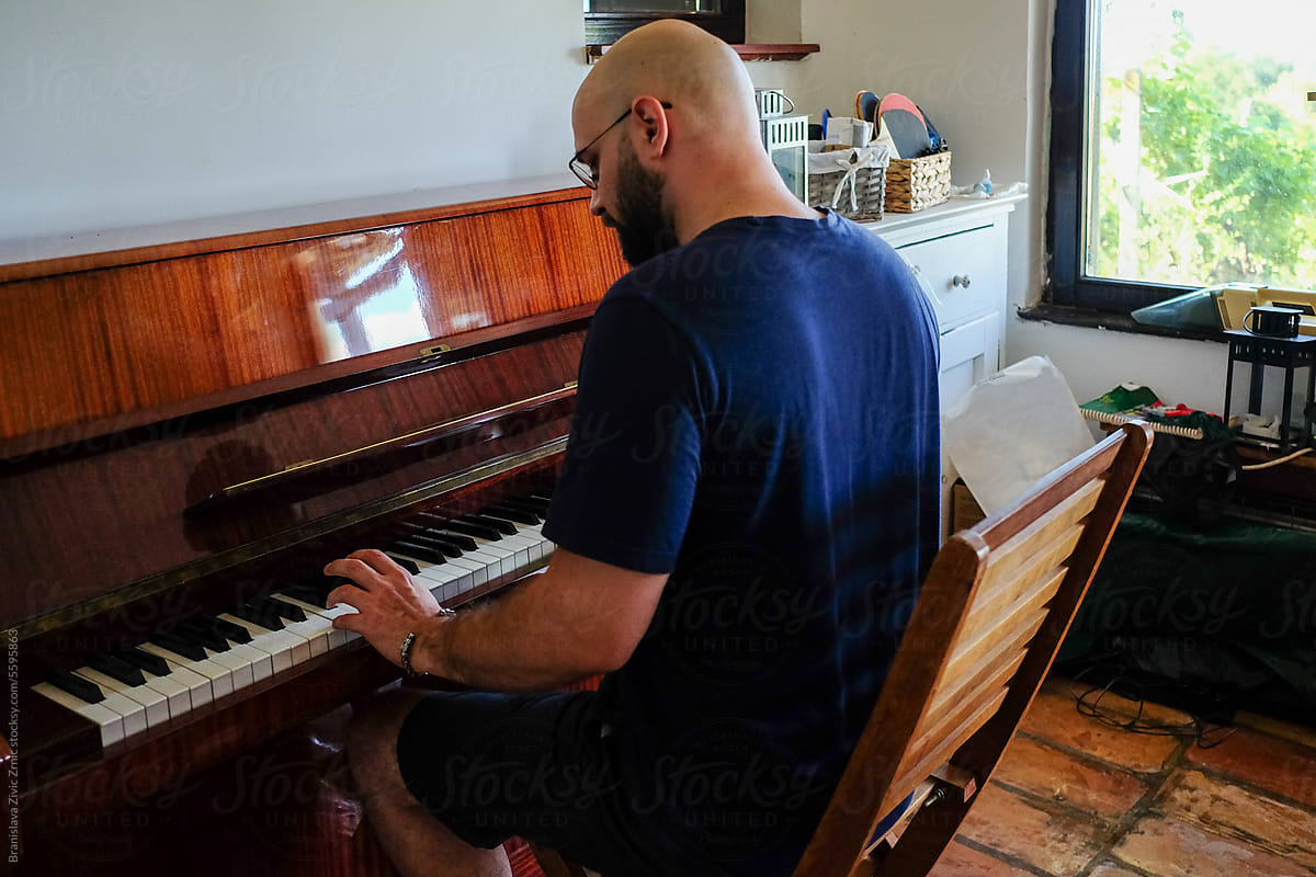 Man Enjoying Playing The Piano At Her Home