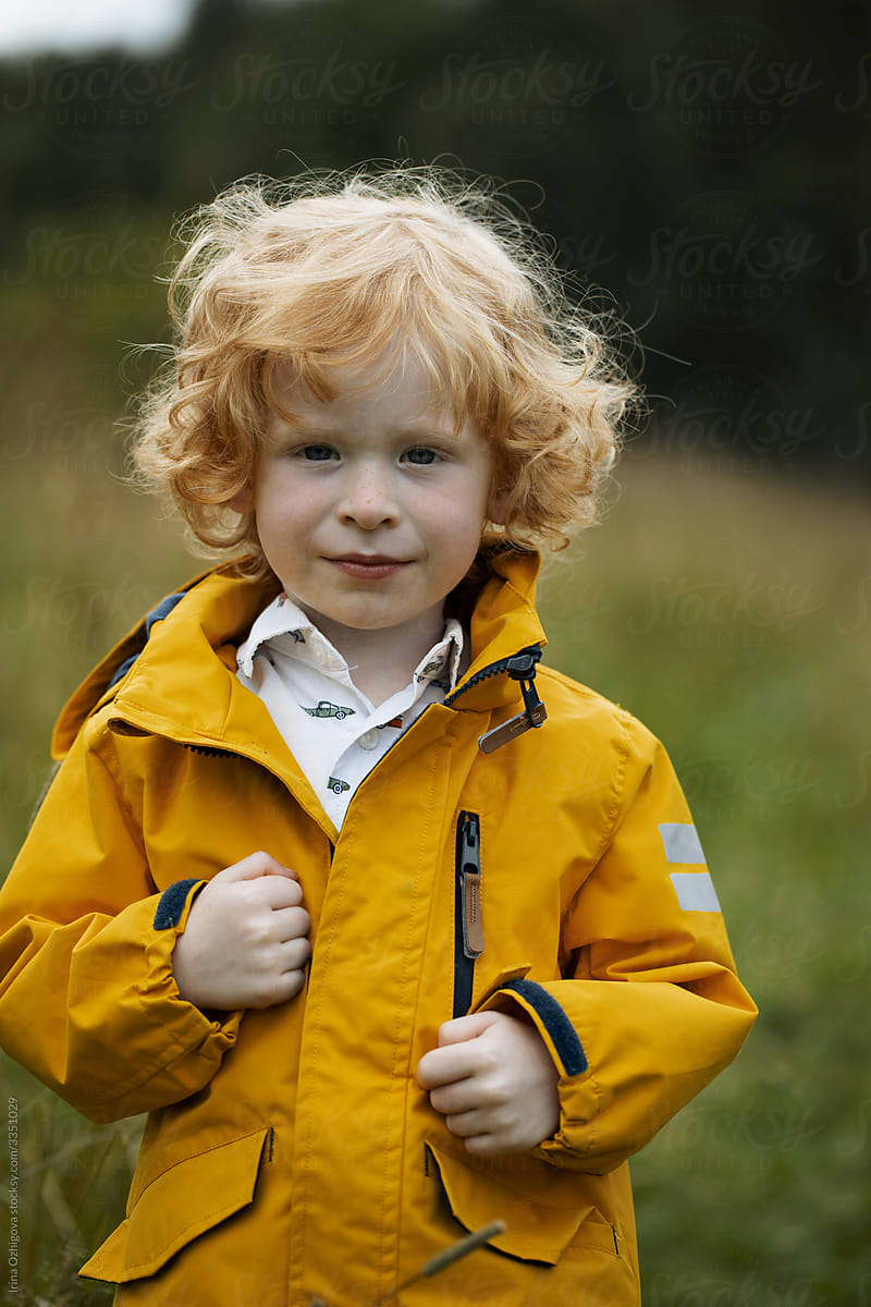 Cute, little boy with a curly, ginger hair outdoors