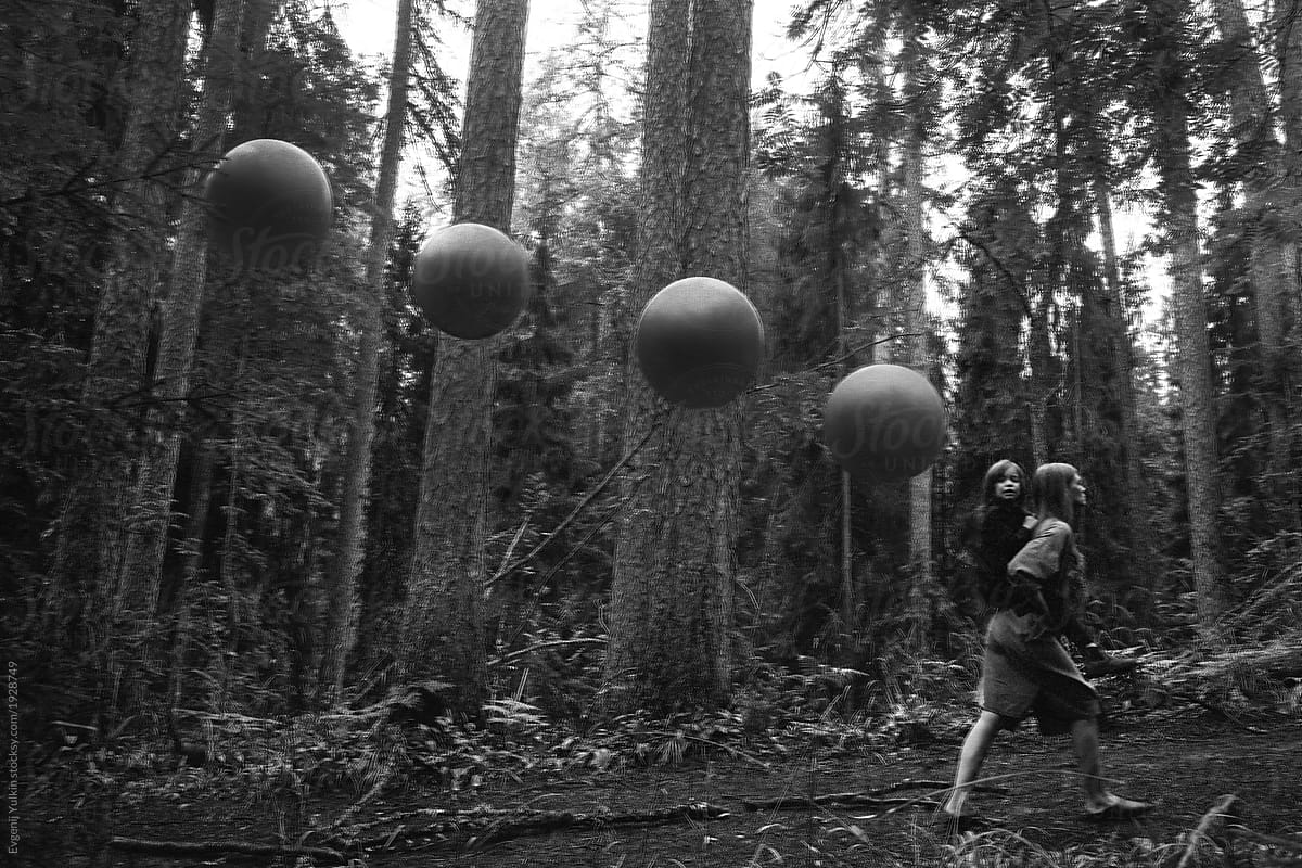 Little girl, mother and spheres in the forest