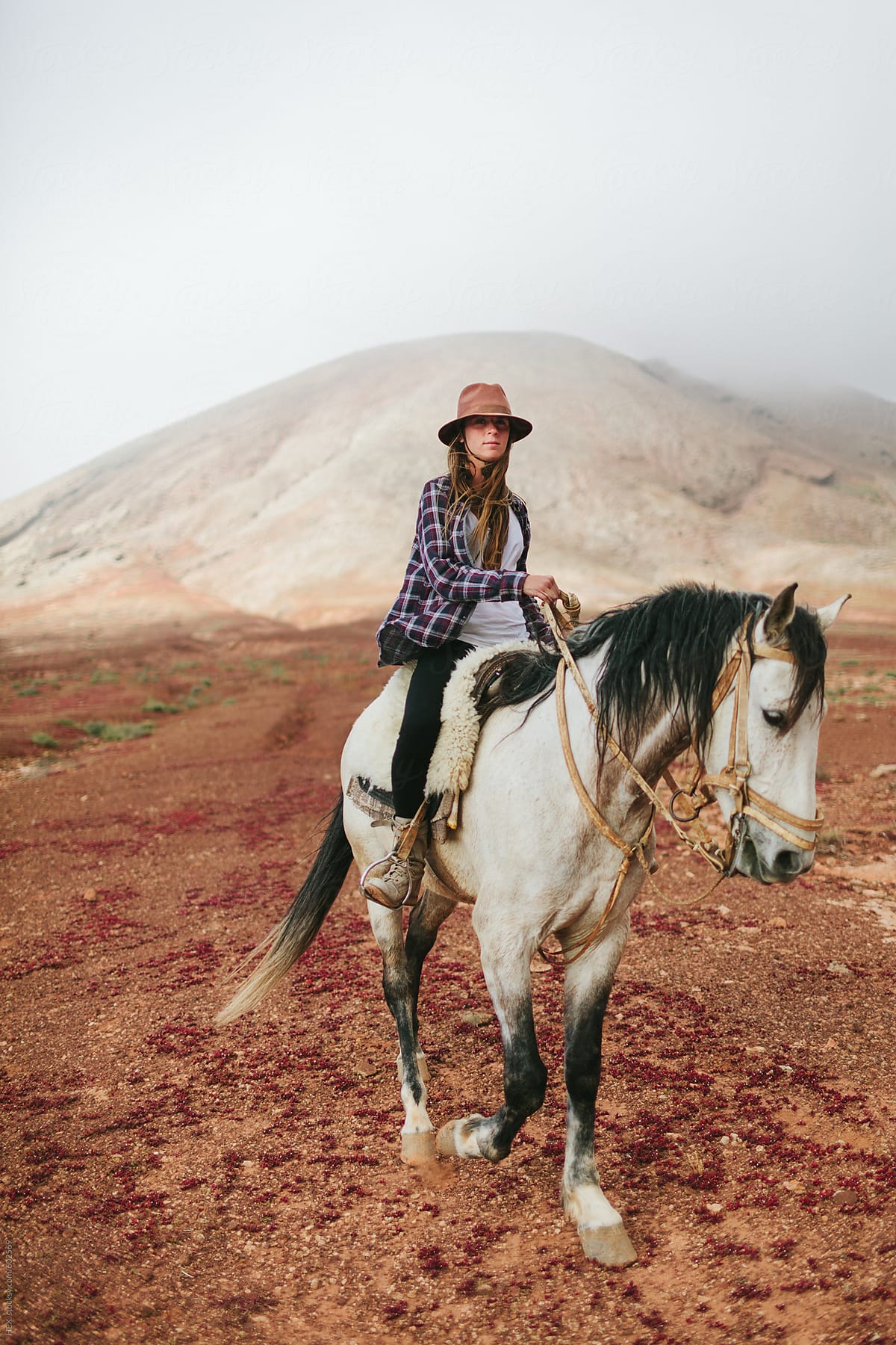 Woman Riding a White Horse in the Middle of a Desert Area