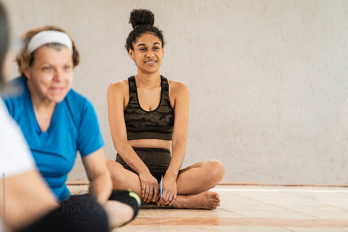 Smiling student during a yoga class sitting on the floor