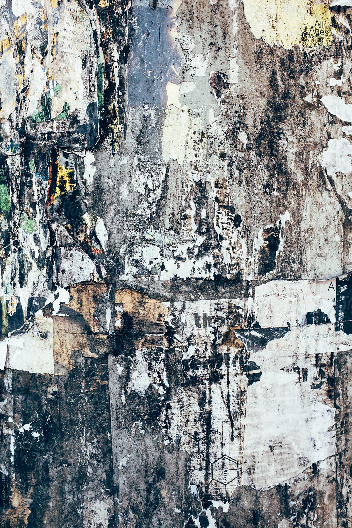 Close up peeling and decaying posters on building wall