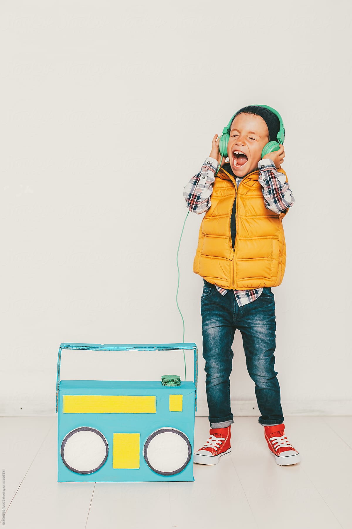 Little hipster boy with diy colored radio singing.