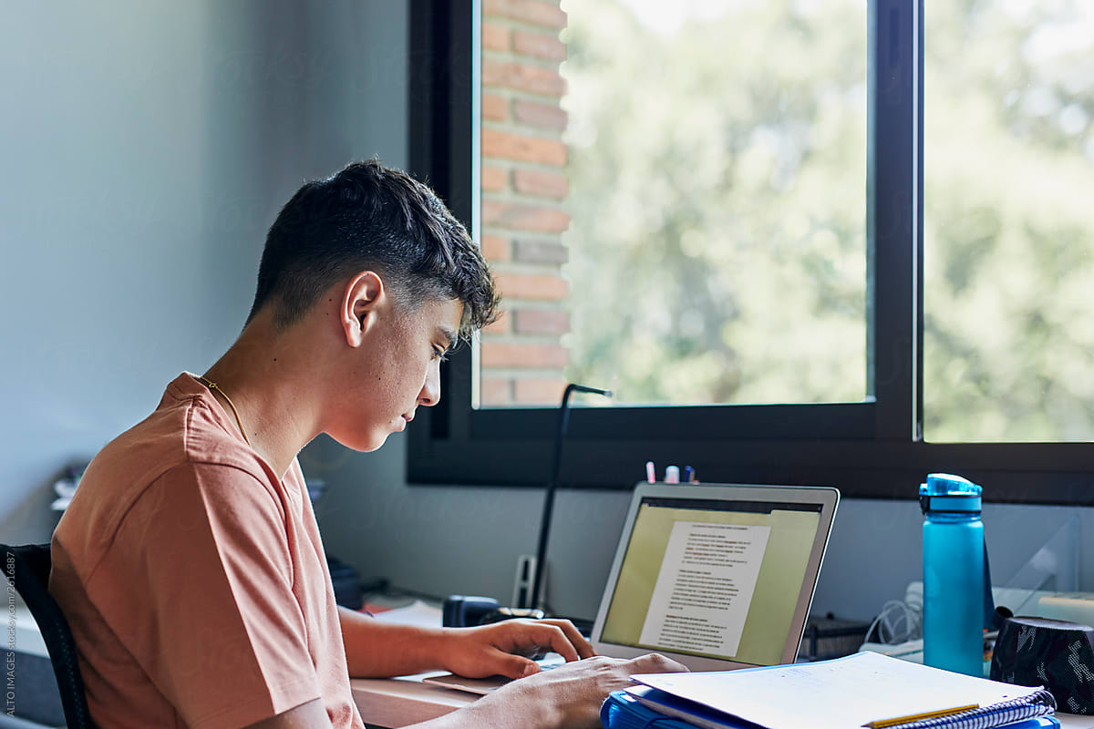 Teenager using laptop studying