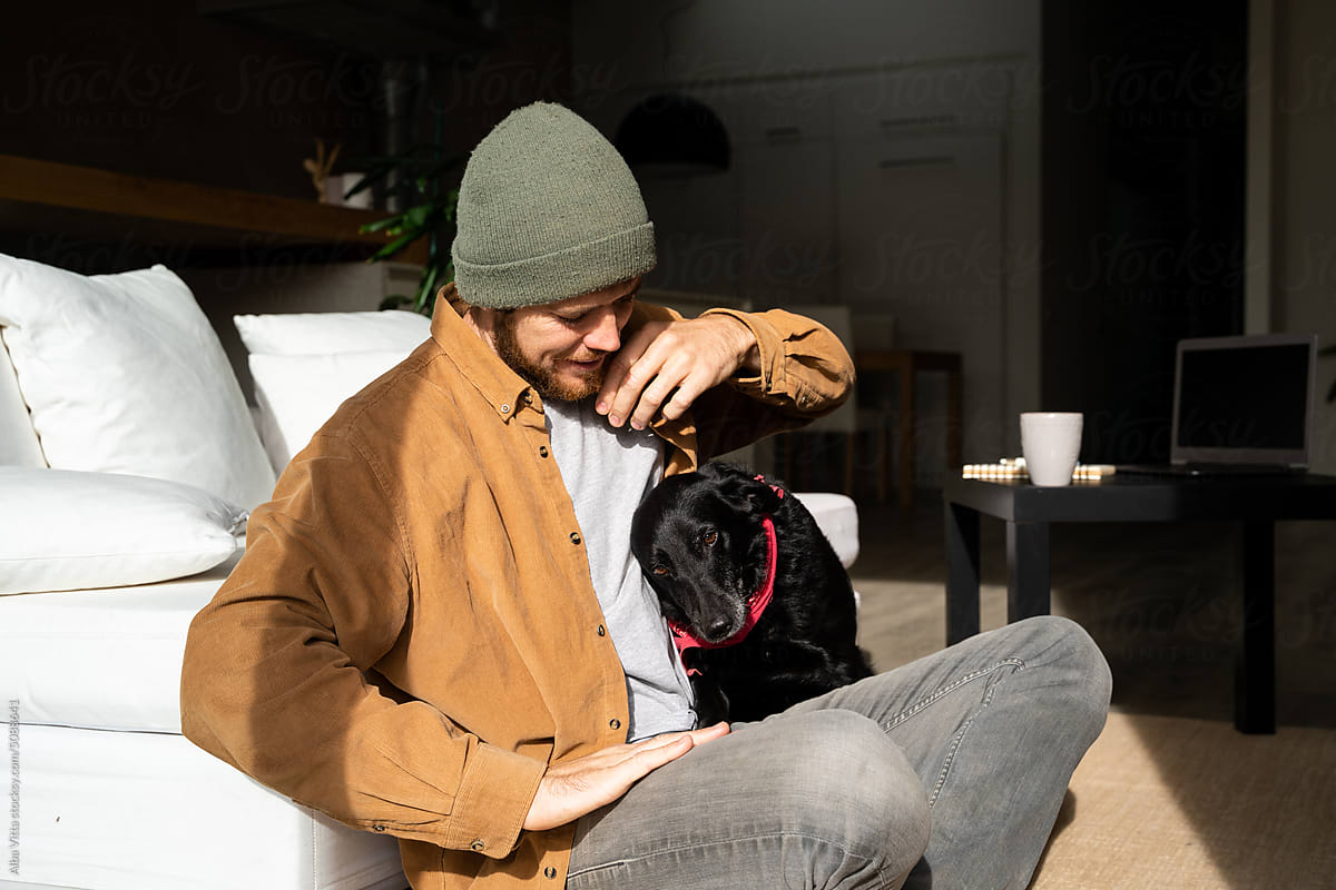 man with dog at home sofa