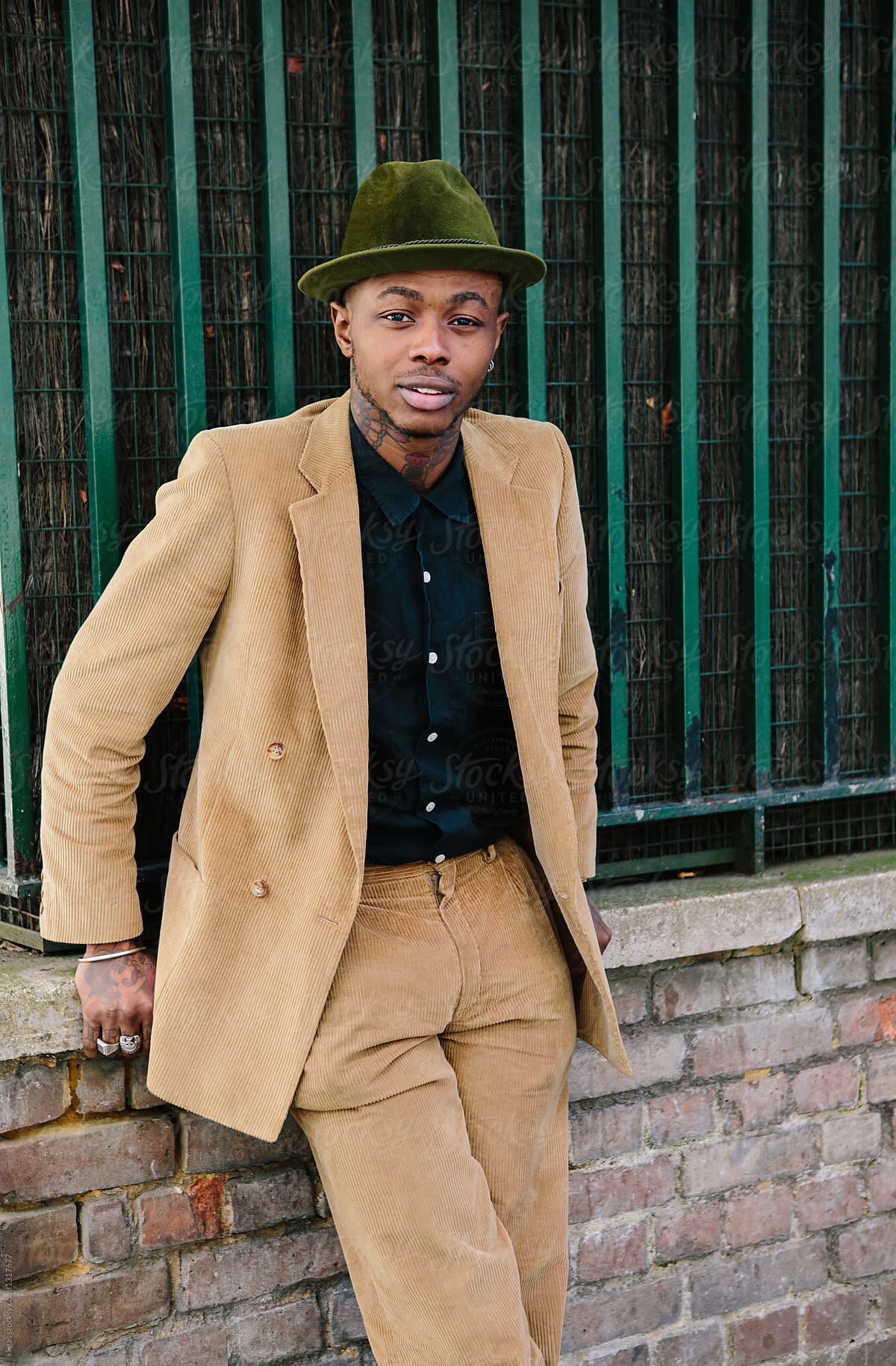 Stylish young black man with tattoos and hat