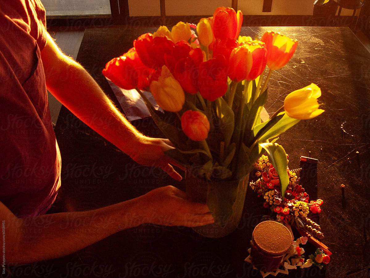 The guy makes a bouquet of tulips