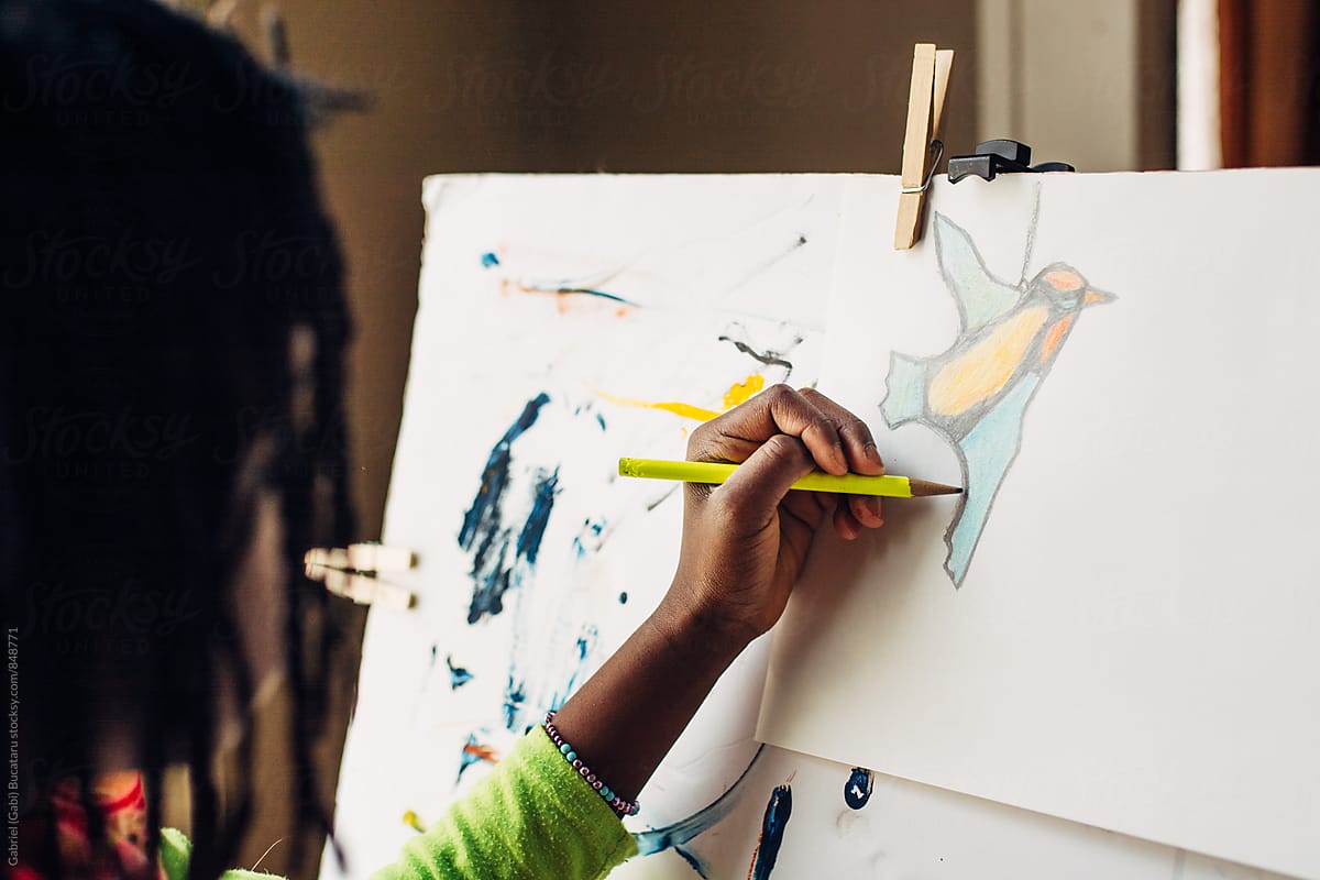 African American girl drawing a colorful bird