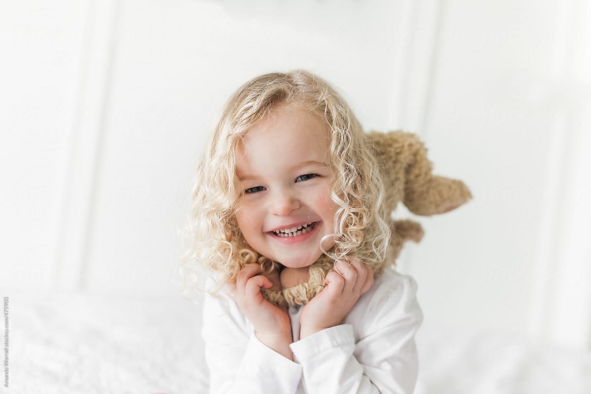 Simple Close Up Of Smiling Young Girl With Blond Curly Hair By