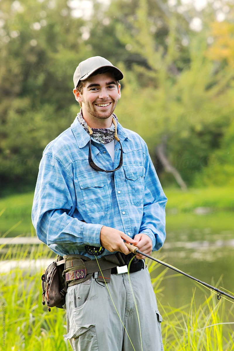 A Young Man Holding His Fly Fishing Rod. by Stocksy Contributor