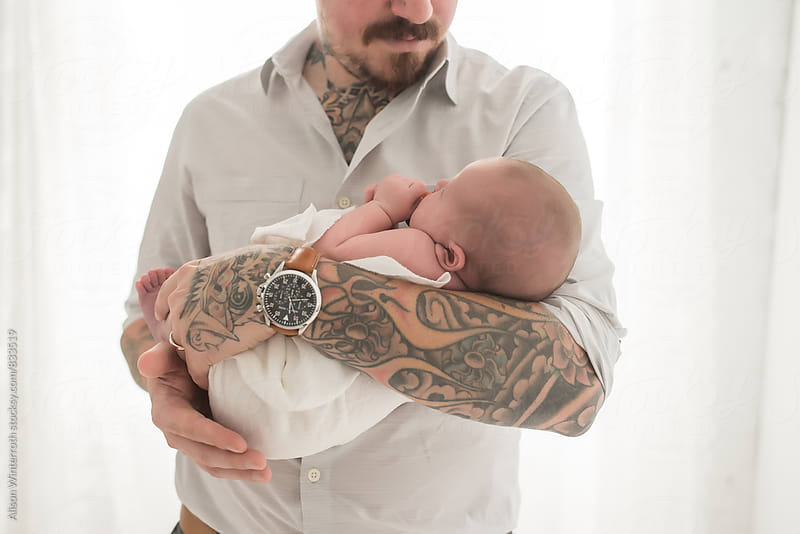 A Tattooed Man Holds His Baby Daughter