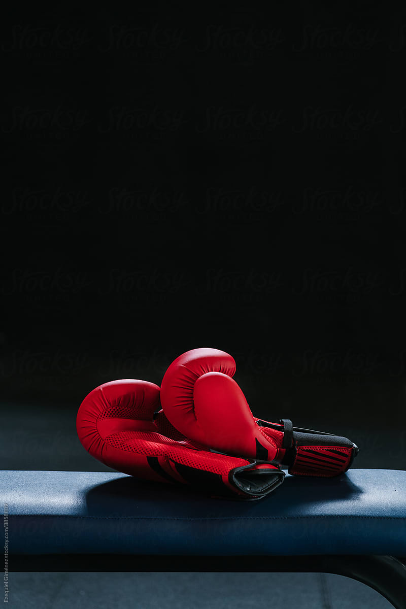 Boxing gloves on bench in dark gym