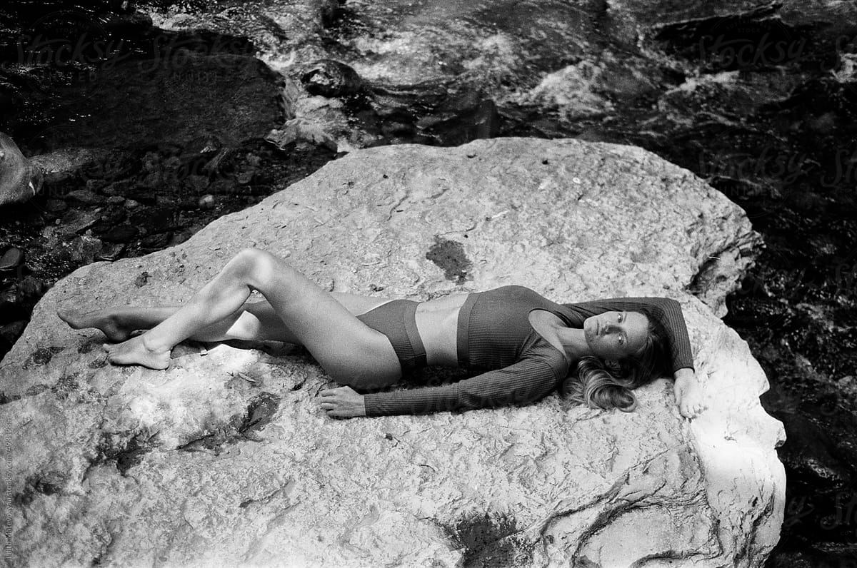 A woman lying on a rock