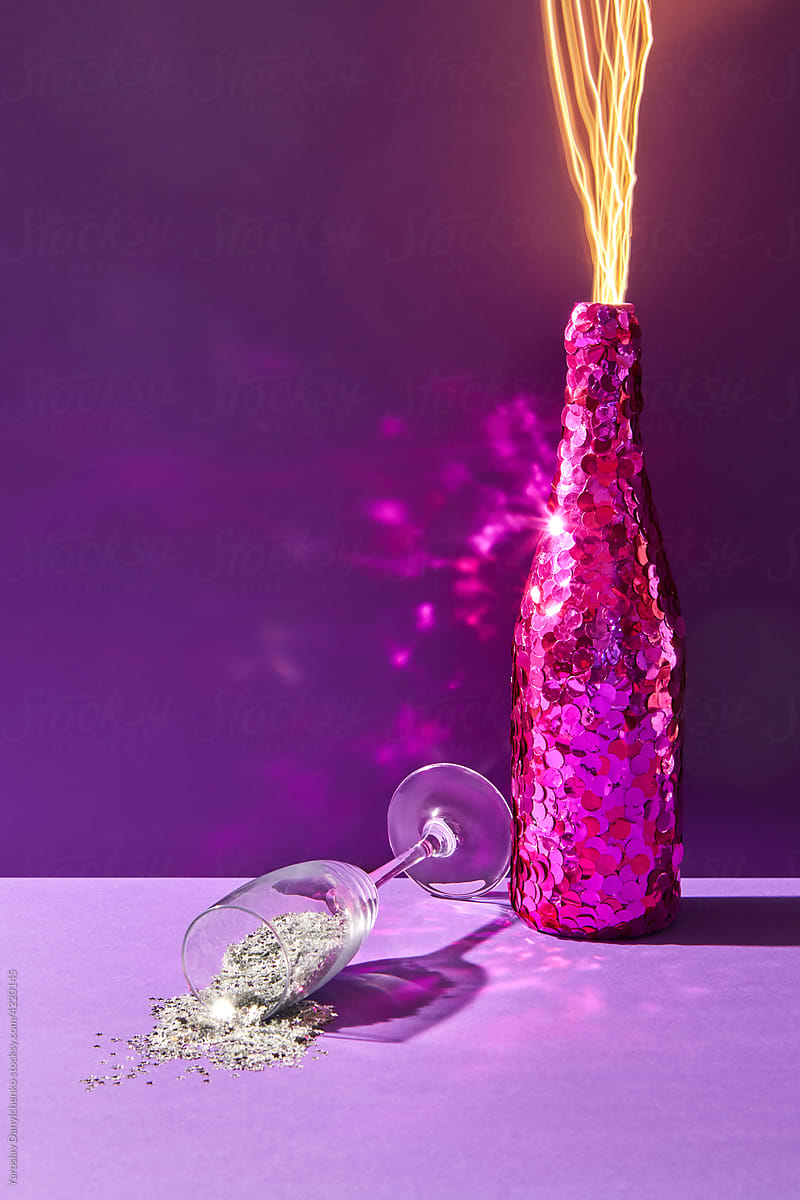 Decorated champagne bottle and glass of glitter