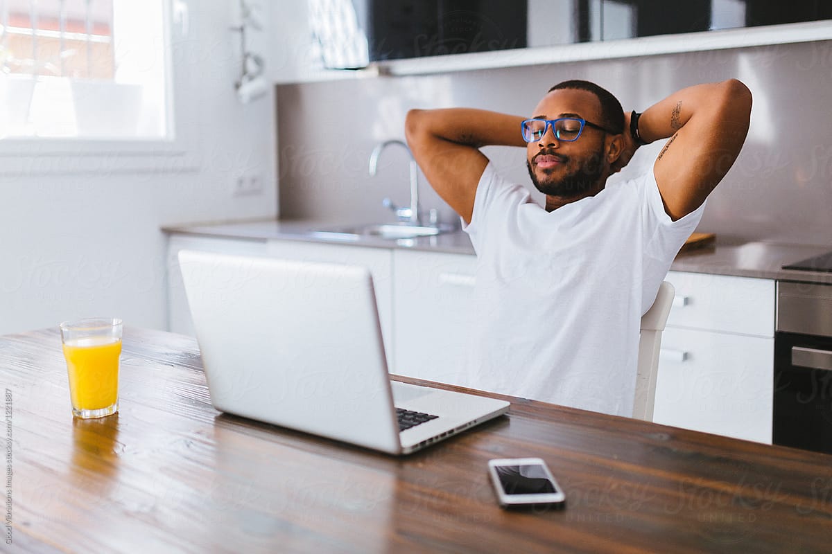 Man relaxing while working with laptop