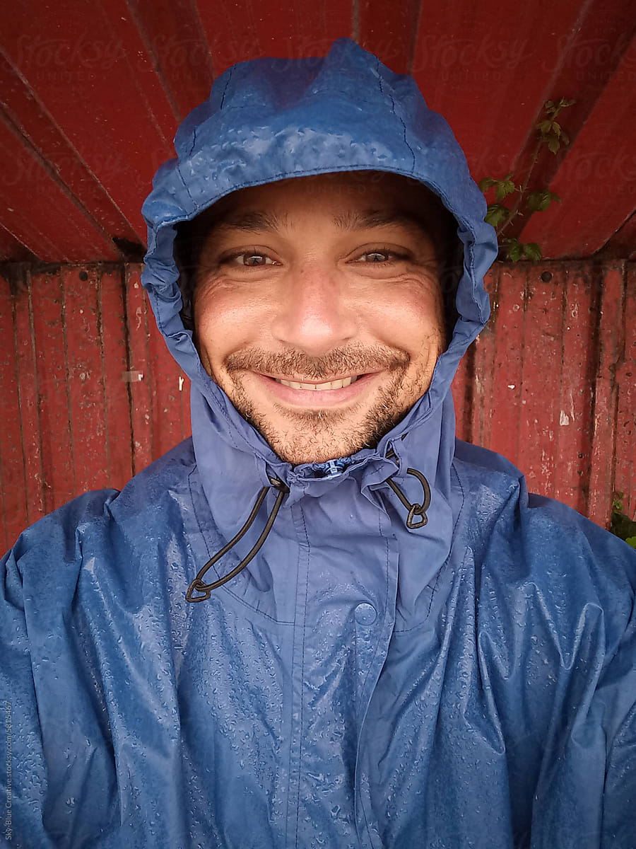 UGC selfie of a smiling hiker wearing a raincoat