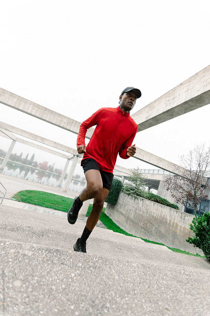 Angular shot of a black athlete running up a flight of stairs